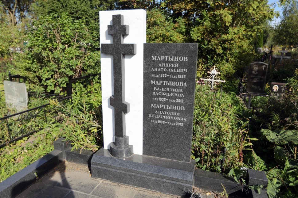 Небольшой семейный памятник с рельефным крестом на фоне белого мрамора