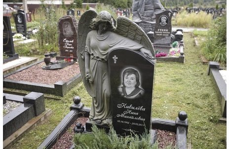 Ангел из черного гранита, обнимающий стелу