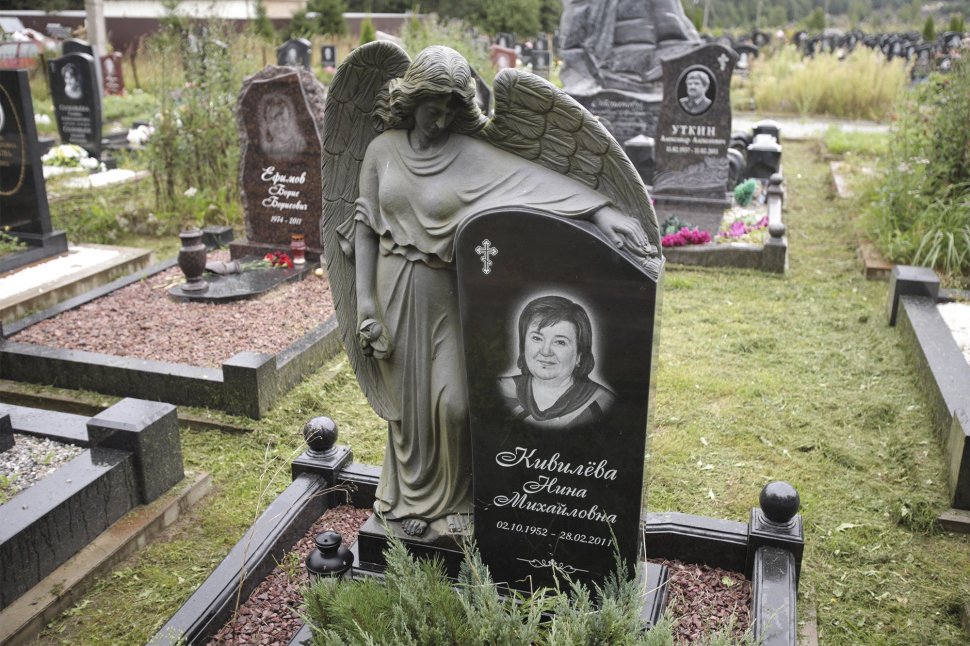 Ангел из черного гранита, обнимающий стелу