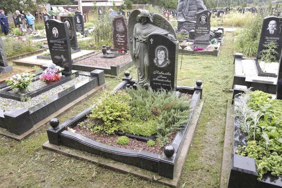 Ангел из черного гранита, обнимающий стелу