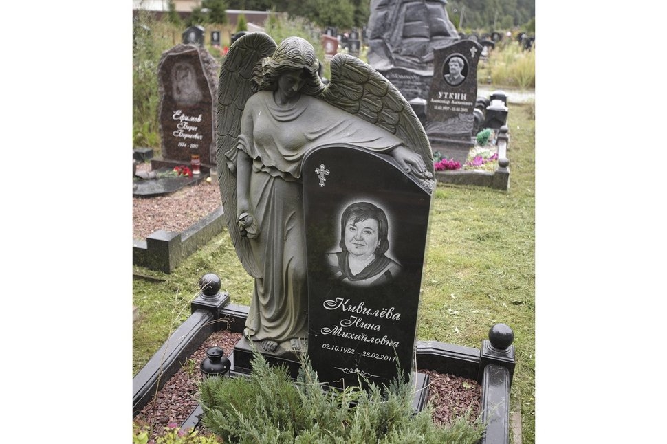 Ангел из черного гранита, обнимающий стелу