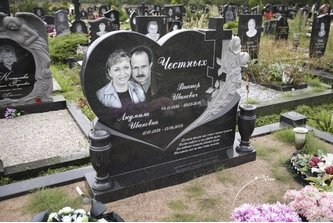 Памятник из черного гранита в форме сердца с розами и крестом