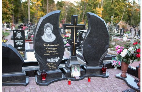 Памятник в форме пламени свечи, разделённого гранитным крестом